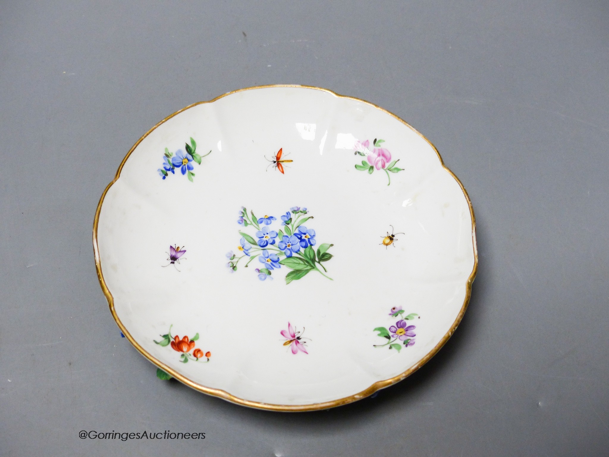 A 19th century Meissen floral encrusted cabinet cup and saucer, decorated with flowers and insects, diameter 12cm